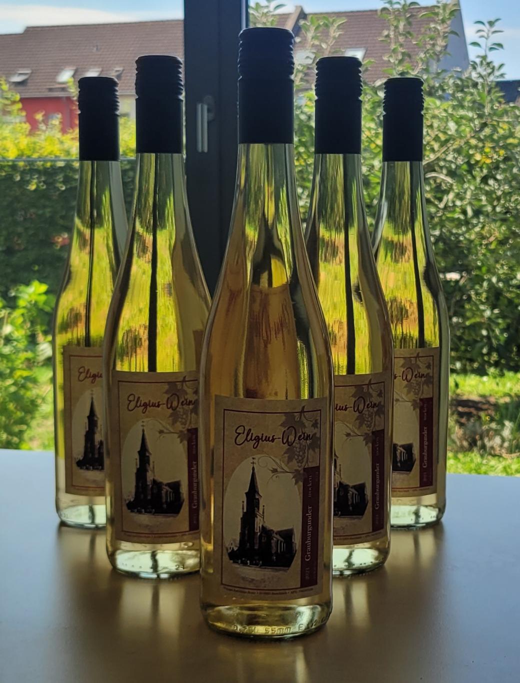 Flaschen mit Weißwein stehen auf einem Tisch