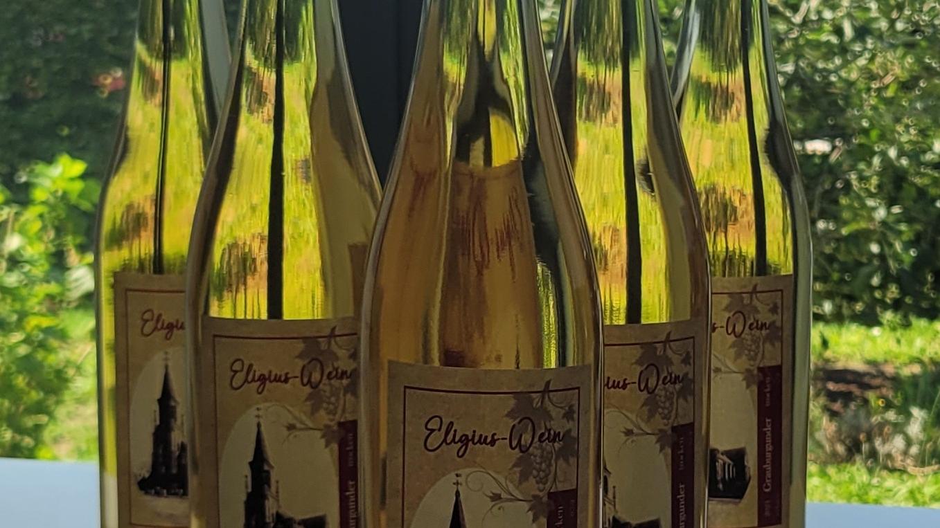 Flaschen mit Weißwein stehen auf einem Tisch