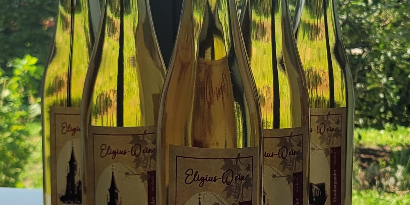 Flaschen mit Weißwein stehen auf einem Tisch