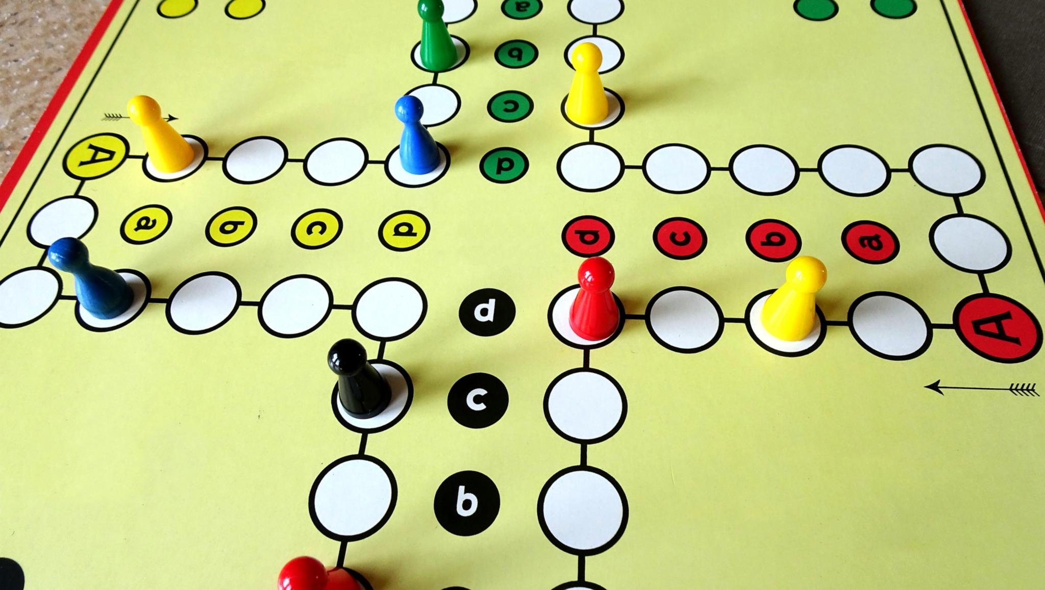 ein Mensch-ärgere-dich-nicht-Spielfeld mit bunten Figuren.