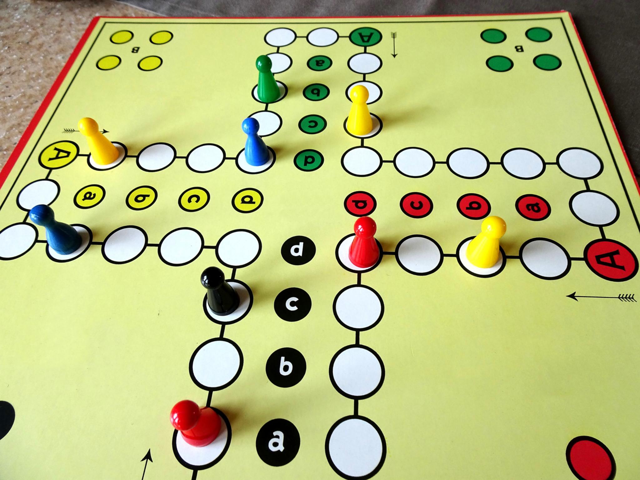 ein Mensch-ärgere-dich-nicht-Spielfeld mit bunten Figuren.