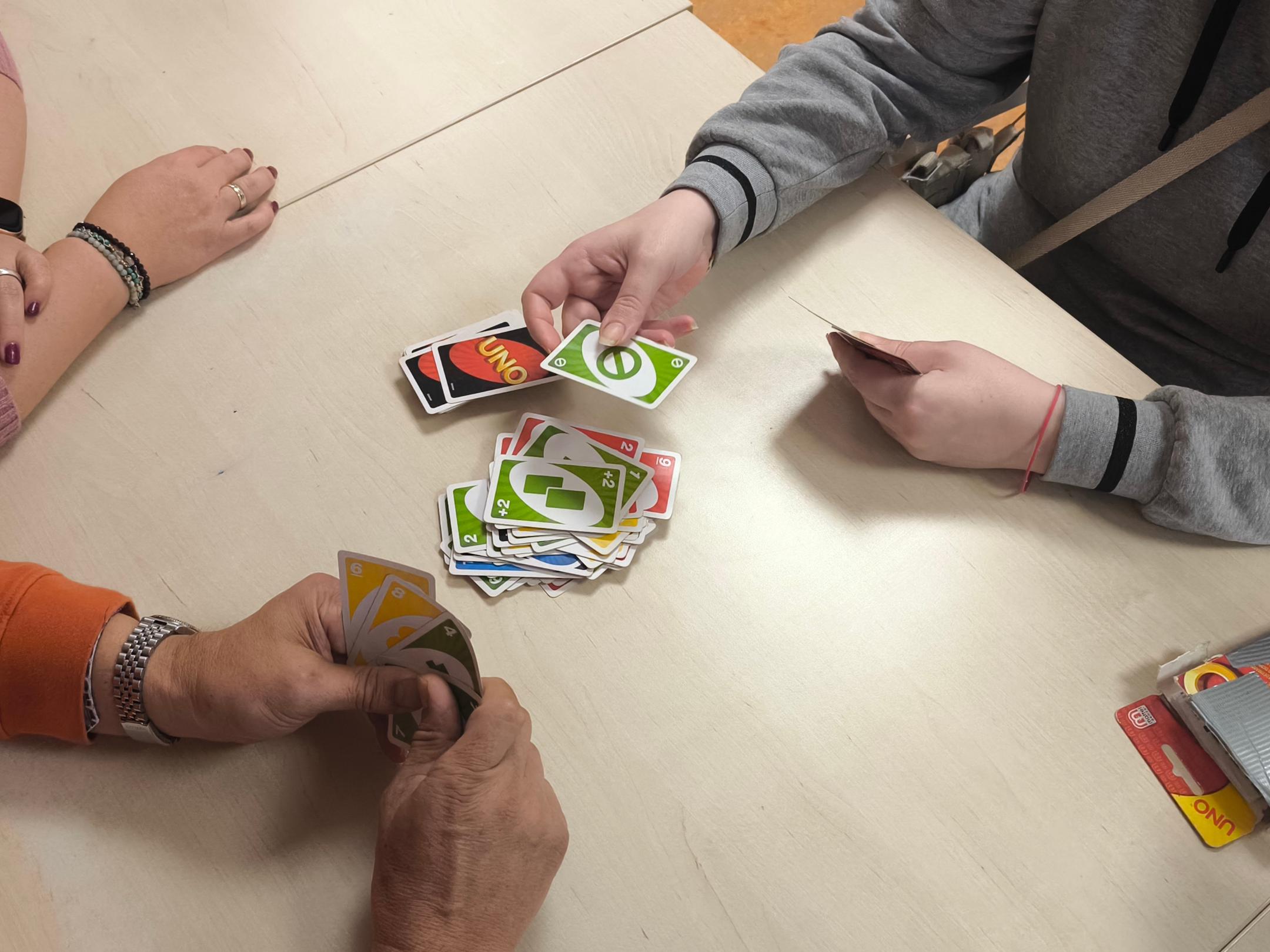 Hände halten bunte Uno-Karten