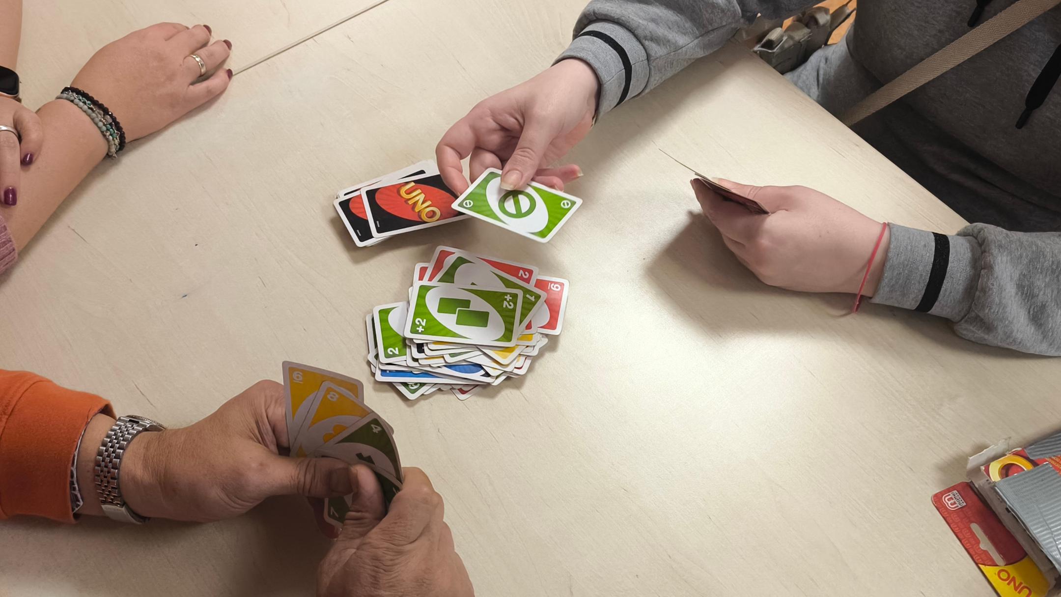 Hände halten bunte Uno-Karten