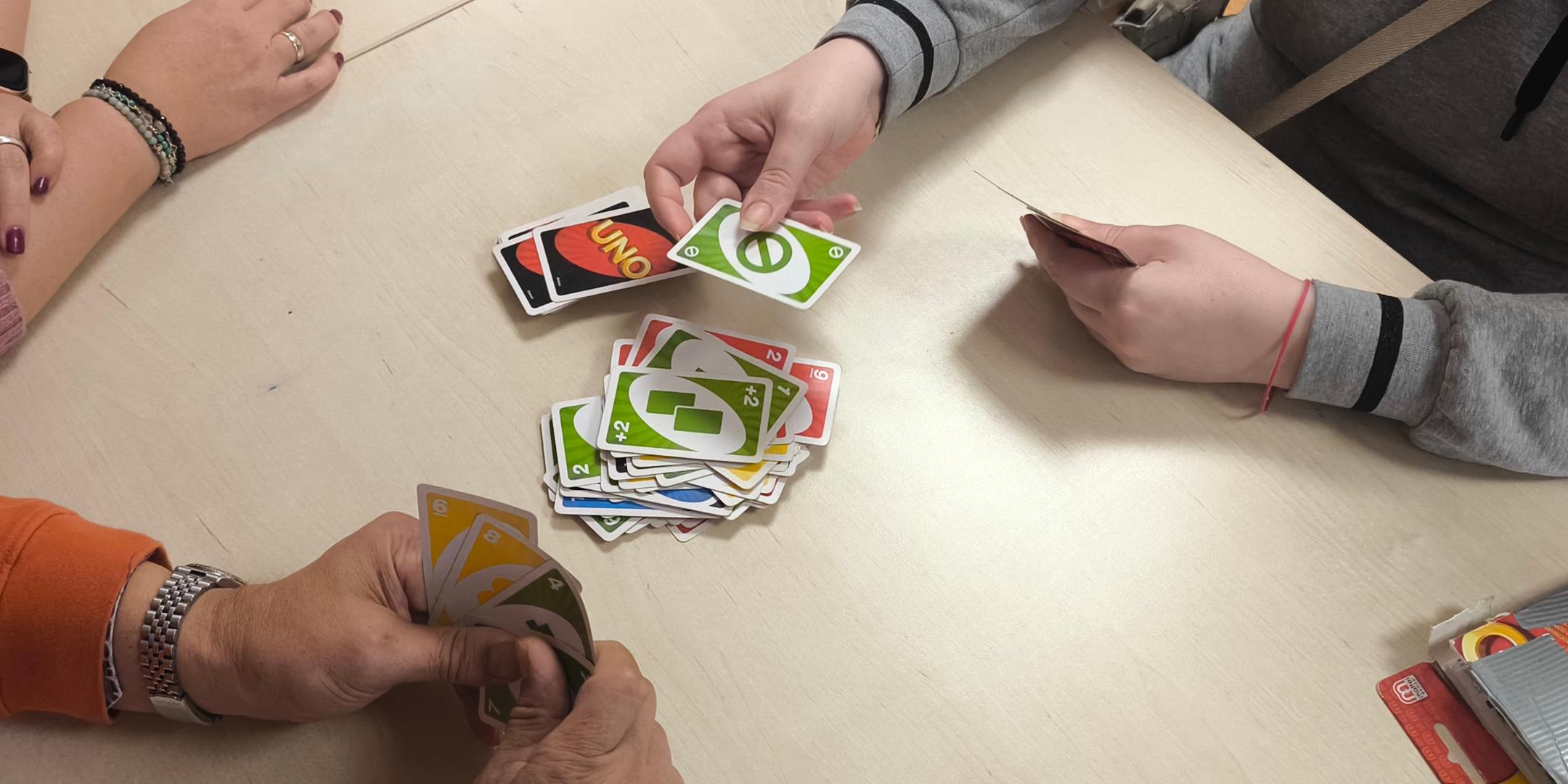 Hände halten bunte Uno-Karten